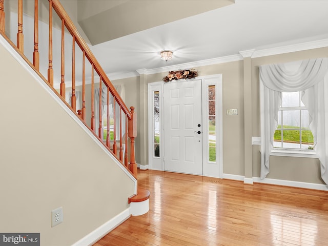 foyer entrance with hardwood / wood-style flooring and ornamental molding