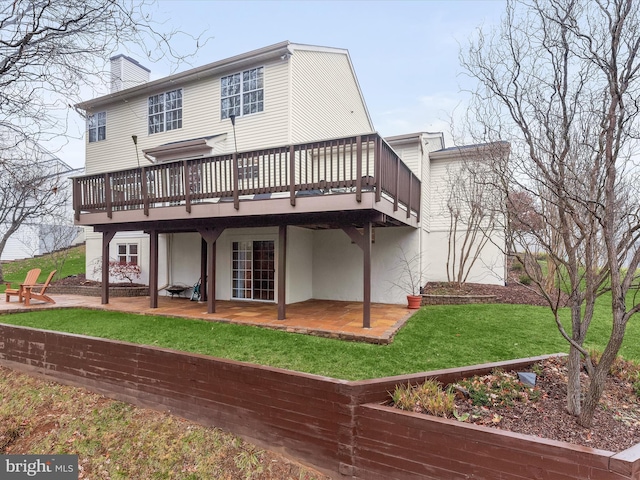 back of house featuring a patio, a deck, and a lawn