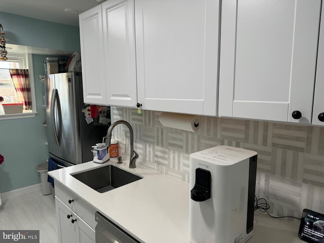 kitchen with white cabinets, tasteful backsplash, dishwasher, and sink