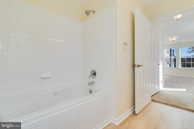 bathroom with tiled shower / bath combo and hardwood / wood-style flooring