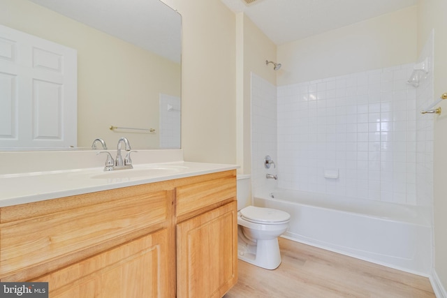 full bathroom with vanity, toilet, wood-type flooring, and tiled shower / bath