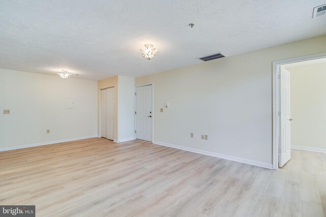 45512 Westmeath Unit B21, Great Mills, MD 20634 - spare room featuring a textured ceiling, light wood-type flooring, baseboards, fire sprinkler in ceiling, and a chandelier