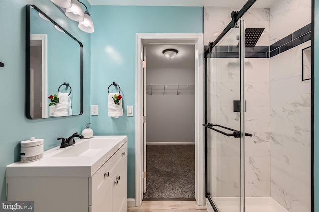 bathroom featuring hardwood / wood-style floors, vanity, and a shower with door