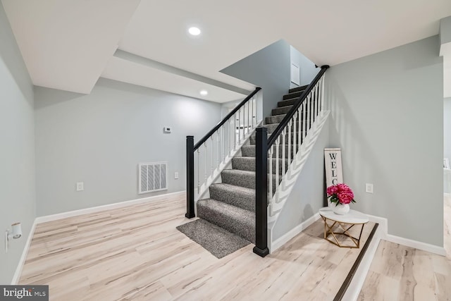 staircase with wood-type flooring