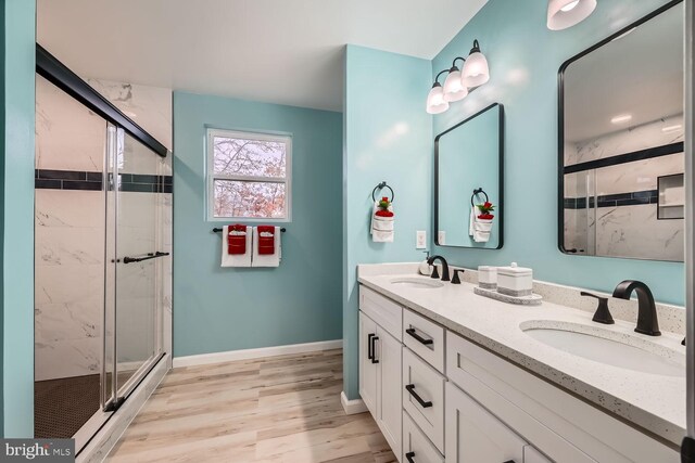 bathroom with vanity, an enclosed shower, and wood-type flooring