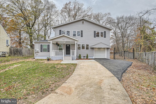 front of property with covered porch, a front yard, and a garage