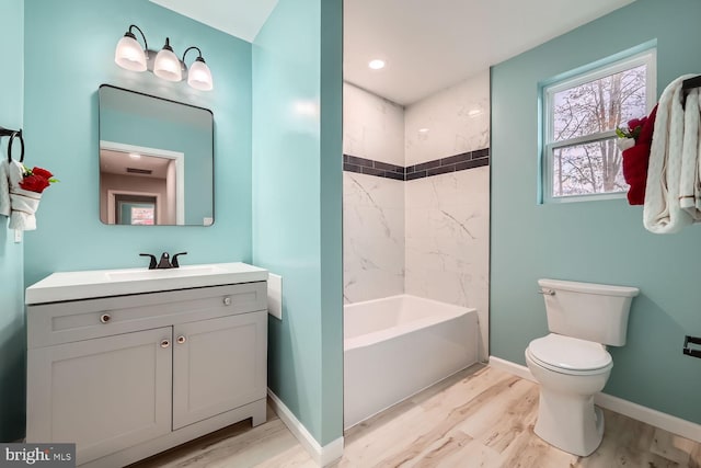 full bathroom featuring hardwood / wood-style flooring, vanity, toilet, and tiled shower / bath