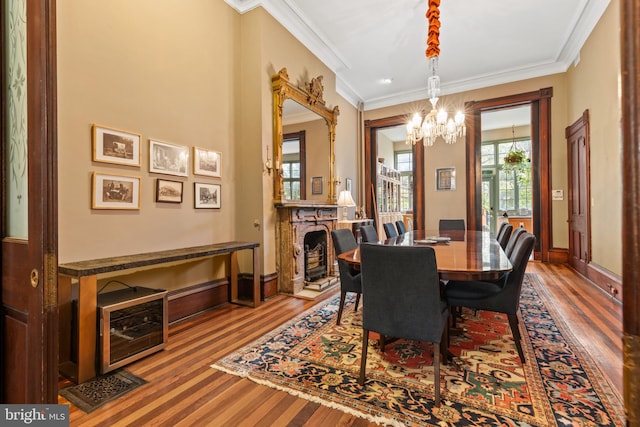 dining space with a notable chandelier, wood-type flooring, and ornamental molding