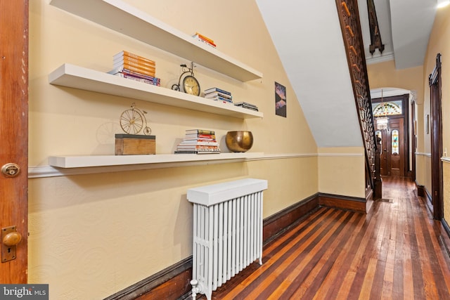 hall with dark hardwood / wood-style floors and vaulted ceiling