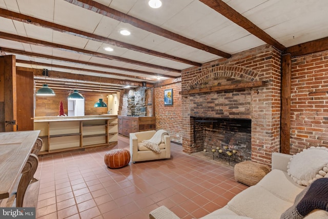 living room featuring tile patterned flooring, beam ceiling, and a brick fireplace