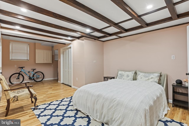 bedroom featuring beam ceiling and light hardwood / wood-style flooring