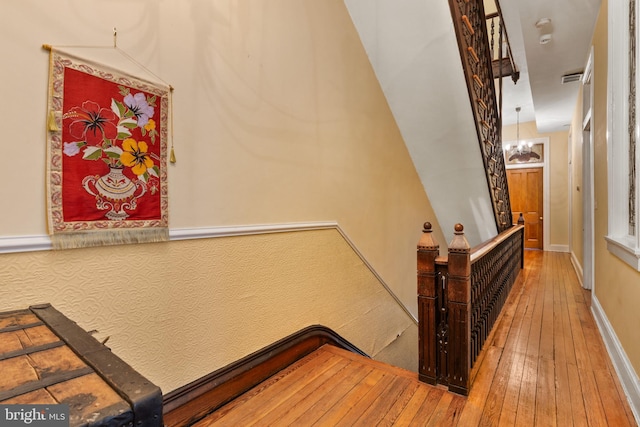 staircase featuring a chandelier and hardwood / wood-style flooring