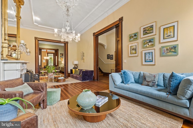 living room featuring a notable chandelier, wood-type flooring, and crown molding