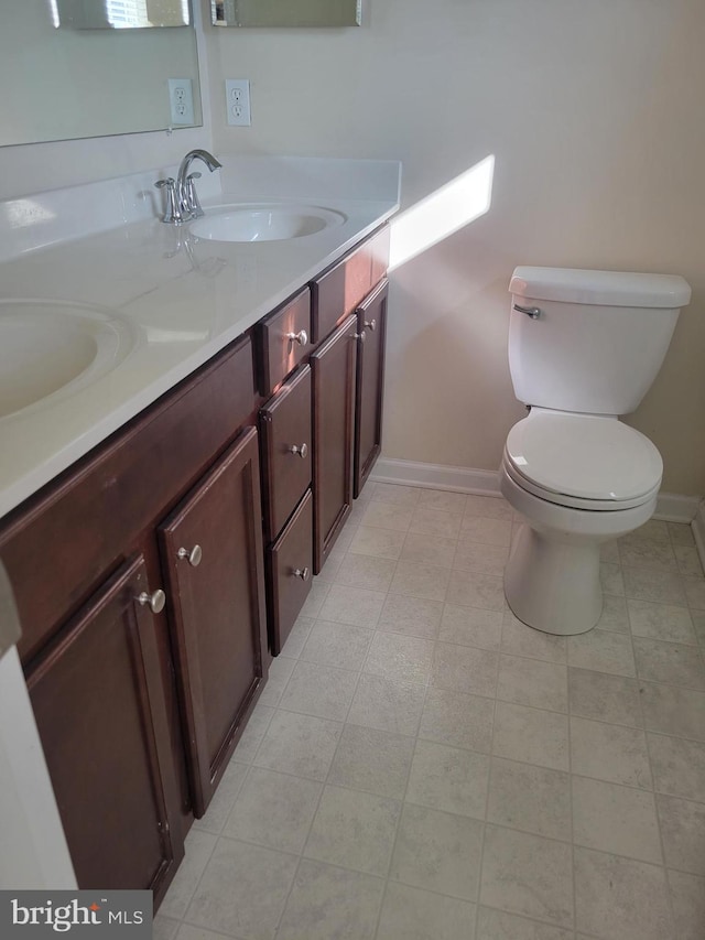 bathroom with tile patterned flooring, vanity, and toilet