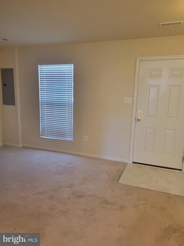 foyer entrance with electric panel and light carpet