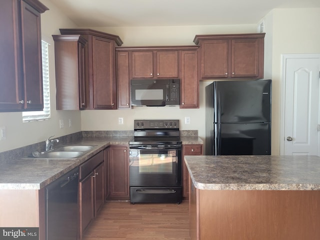 kitchen featuring sink, light hardwood / wood-style flooring, and black appliances