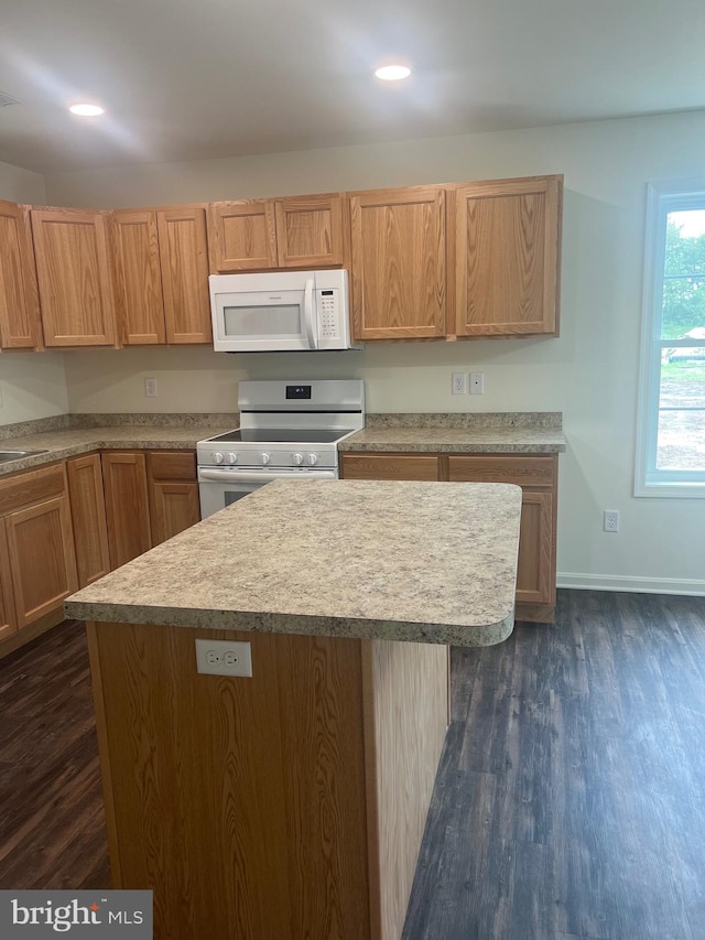 kitchen with dark hardwood / wood-style flooring, a center island, stainless steel range oven, and sink