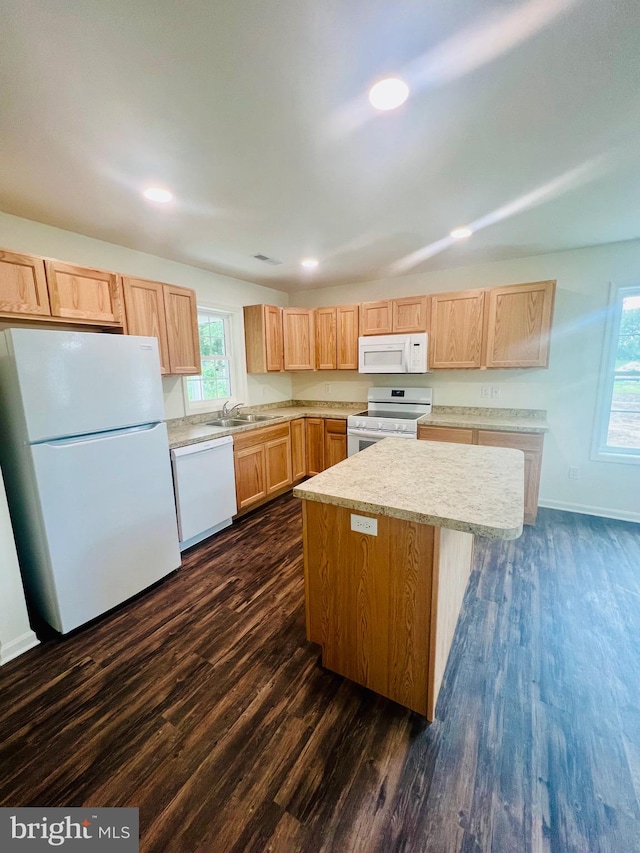 kitchen featuring dark hardwood / wood-style flooring, white appliances, a center island, and sink