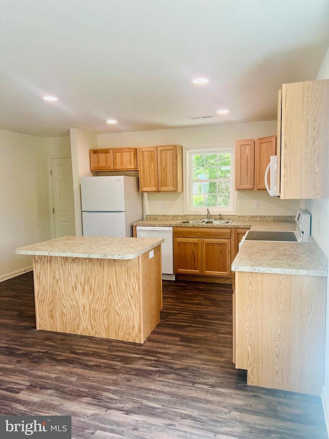 kitchen with light brown cabinets, a center island, sink, dark hardwood / wood-style floors, and white appliances