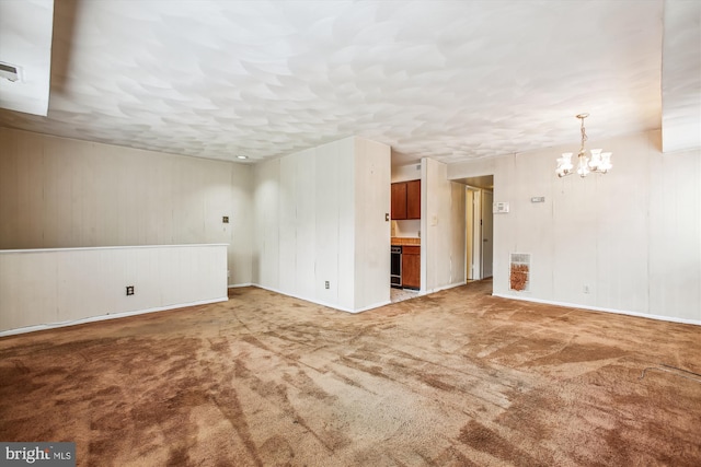 unfurnished room with carpet flooring and an inviting chandelier