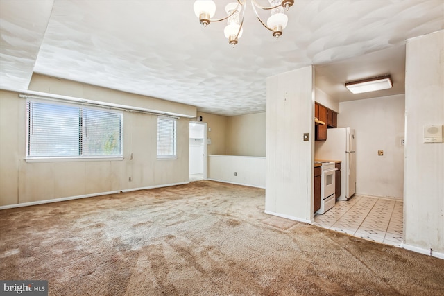 unfurnished living room with light colored carpet and a notable chandelier