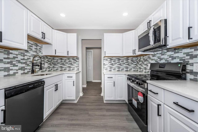 kitchen featuring appliances with stainless steel finishes, backsplash, dark hardwood / wood-style floors, and white cabinetry