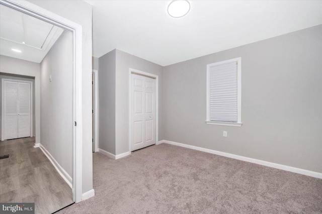 unfurnished bedroom featuring a closet and light colored carpet