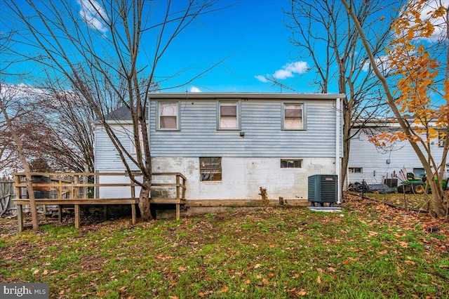 back of property featuring a yard, central AC unit, and a deck