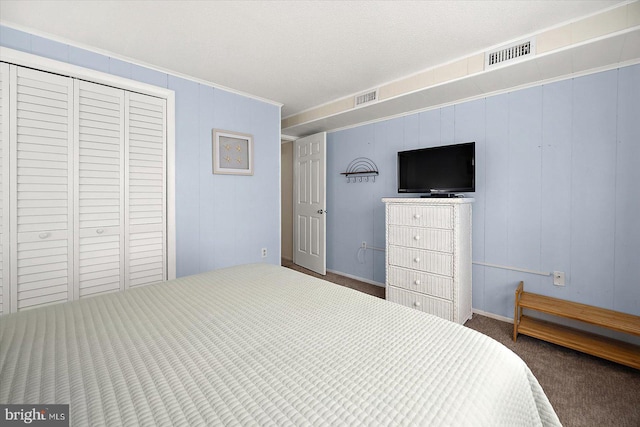 bedroom with carpet, a textured ceiling, a closet, and wooden walls