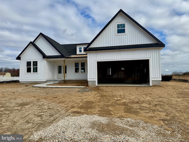 modern farmhouse with a porch and a garage