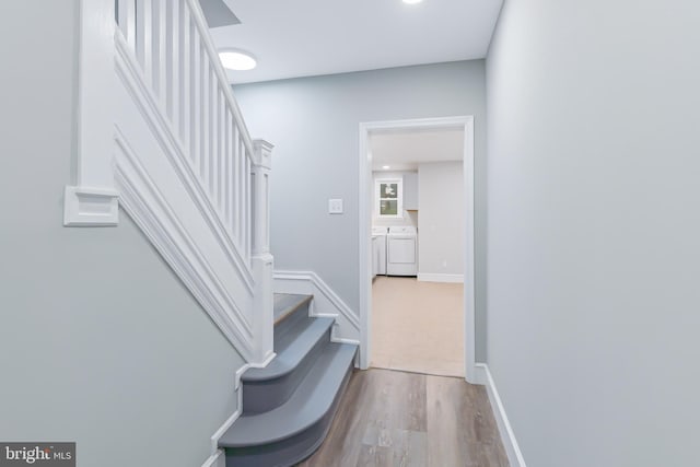 stairway featuring washer and clothes dryer and wood-type flooring