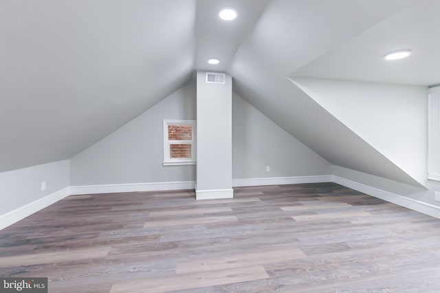 additional living space featuring light hardwood / wood-style floors and lofted ceiling