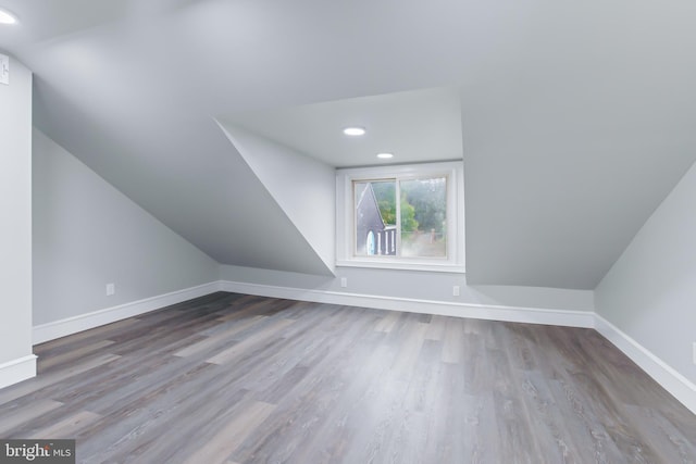 additional living space featuring hardwood / wood-style floors and lofted ceiling