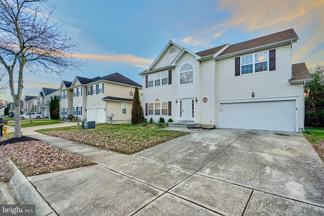 view of front of home with a garage and central air condition unit