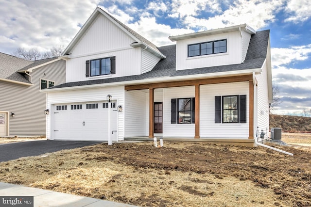 view of front of home featuring a porch, a garage, and central air condition unit