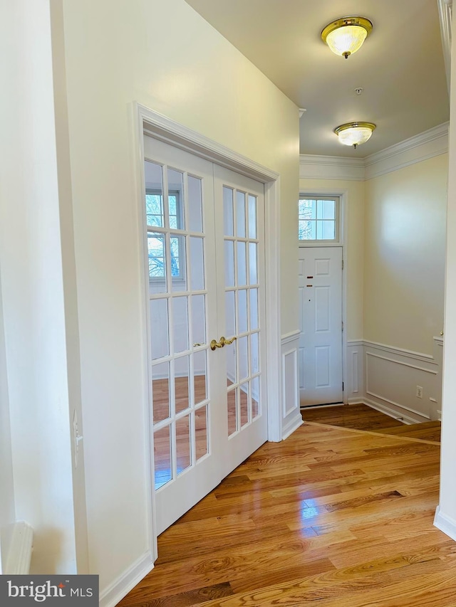 entryway with french doors, light hardwood / wood-style flooring, and crown molding