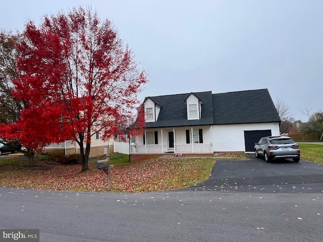 cape cod house with a porch and a garage