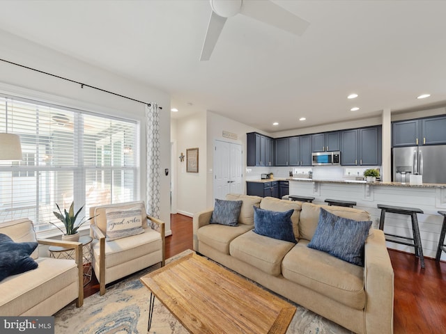 living room with ceiling fan and dark hardwood / wood-style flooring