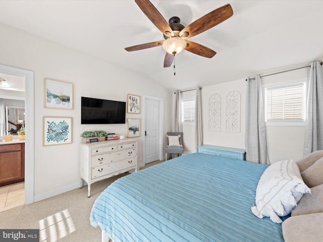 carpeted bedroom featuring ceiling fan, connected bathroom, and vaulted ceiling