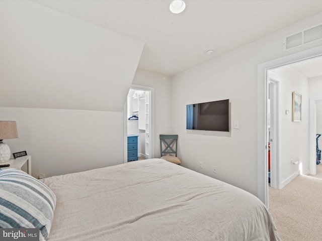 carpeted bedroom featuring a spacious closet and lofted ceiling