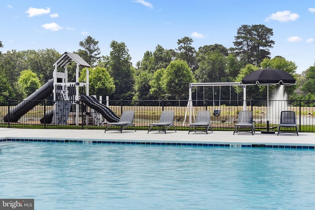 view of swimming pool with a playground