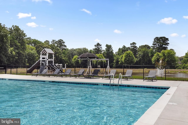 view of swimming pool with a playground