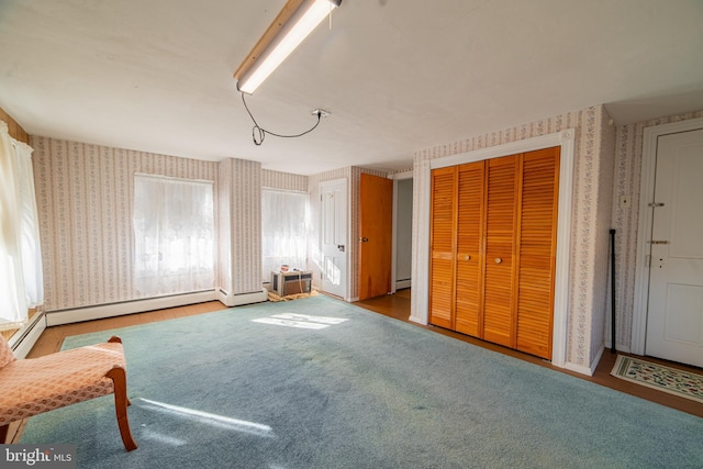 unfurnished room with light colored carpet and a baseboard heating unit