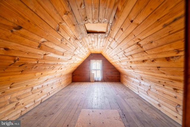 additional living space featuring wood ceiling, wooden walls, wood-type flooring, and lofted ceiling