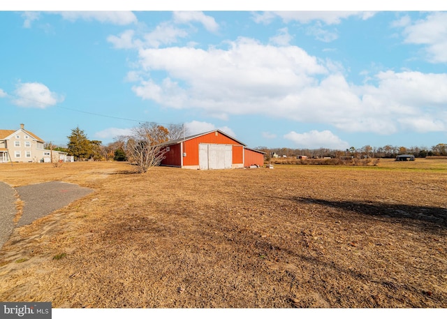 view of yard featuring a rural view and an outdoor structure