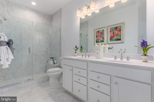 bathroom featuring vanity, toilet, and a shower with shower door