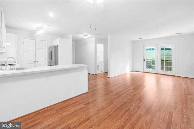 unfurnished living room with sink and light hardwood / wood-style flooring