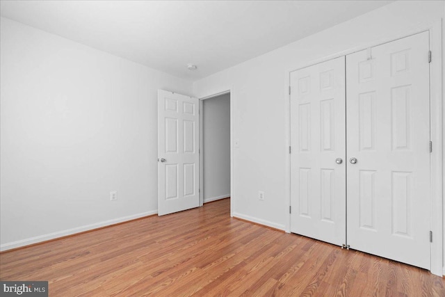 unfurnished bedroom featuring light hardwood / wood-style floors and a closet