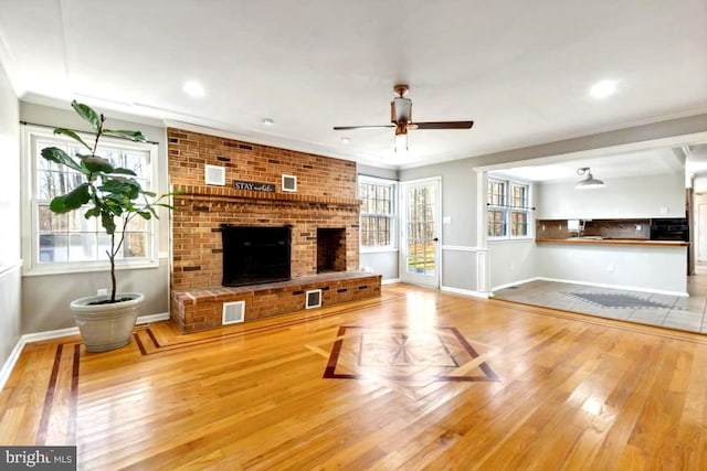 living room with wood-type flooring, ceiling fan, and crown molding