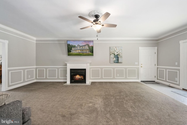 unfurnished living room with carpet, ceiling fan, and crown molding